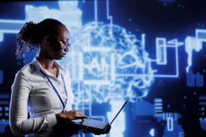 A person in a white shirt holds a laptop in front of a digital brain illustration with "AI" integrated, surrounded by tech elements and diagrams.
