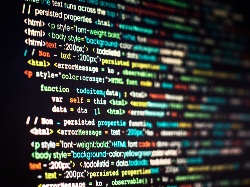 Close-up of a computer screen displaying colorful lines of code written in JavaScript with embedded HTML and CSS. Syntax highlighting shows keywords, variables, and functions in green, blue, red, orange, and white. Tags like and style attributes such as and are visible, illustrating a web development interface.
