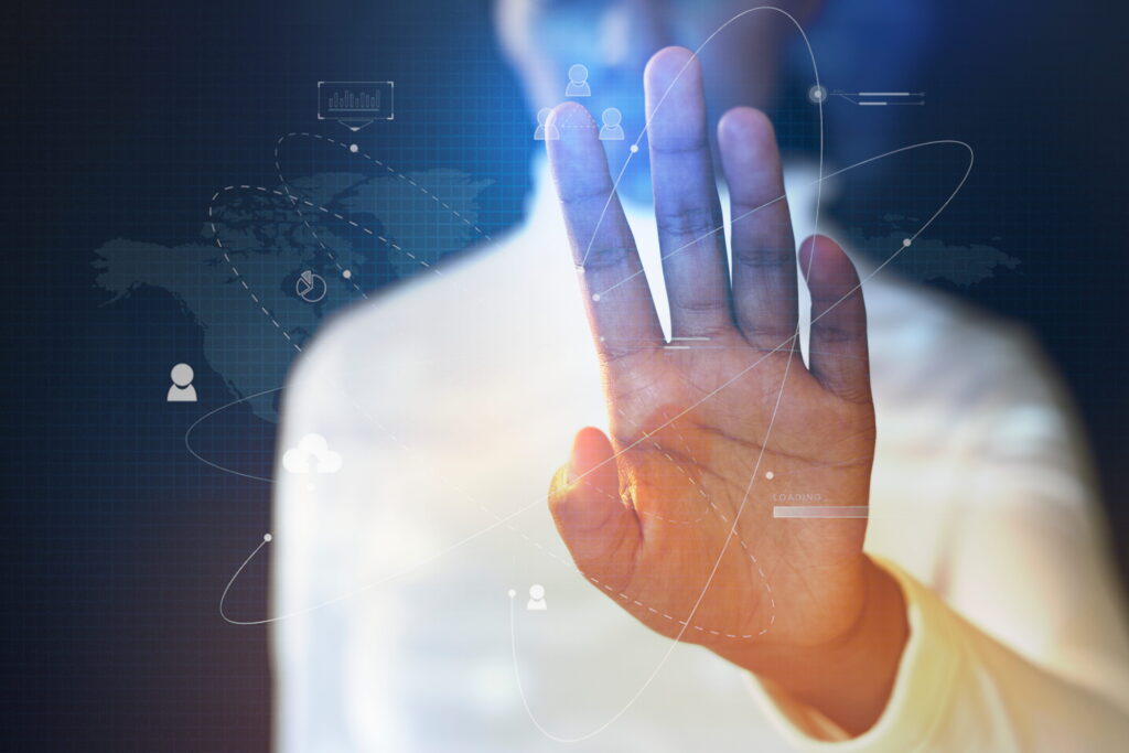 A close-up focus on a person's open palm raised to interact with a glowing digital interface, representing ethical technology.