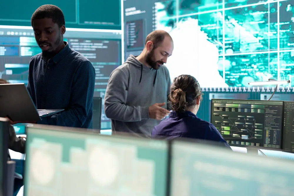 Cybersecurity professionals analysing network security data and monitoring digital systems in a modern security operations centre.