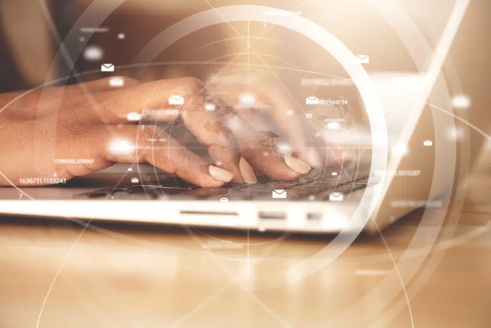 Person using a laptop with a digital network overlay, symbolising digital transformation, information technology, data communication and global connectivity.