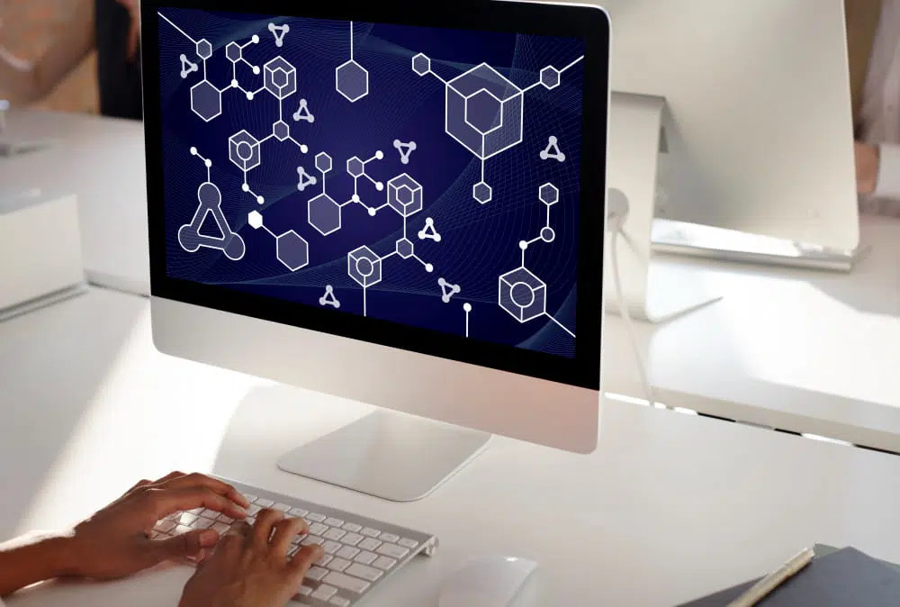 Computer displaying an AI-powered digital network with connected data nodes, illustrating machine learning, artificial intelligence and information technology systems.